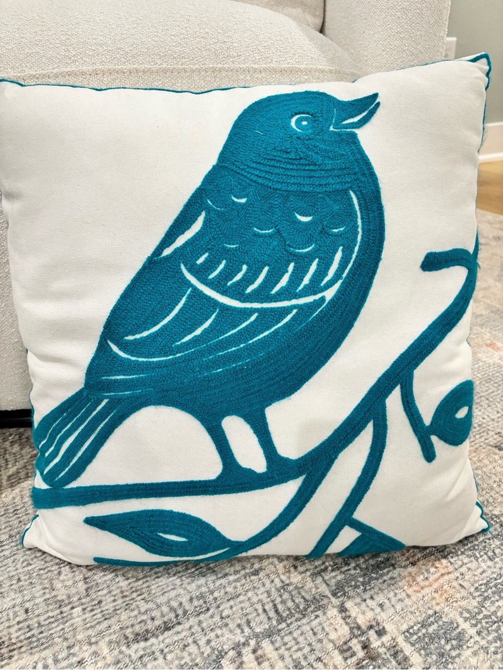 Teal embroidered bird throw pillow